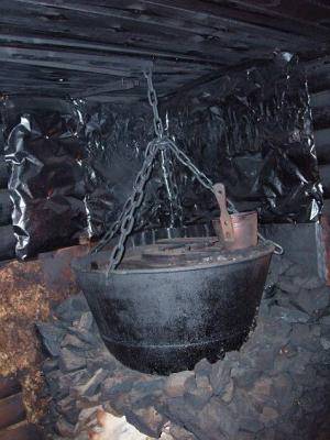 Водяной котел, подвешенный на цепях в бане по-черному