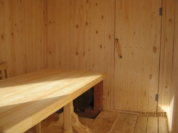 Обшивка стен древесиной и правильное расположение печи для максимальной экономии пространства