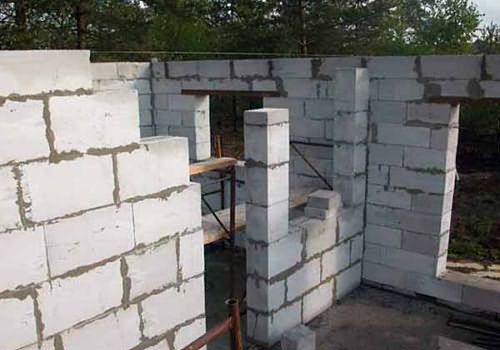 На фото: строительство стен бани из пеноблоков.